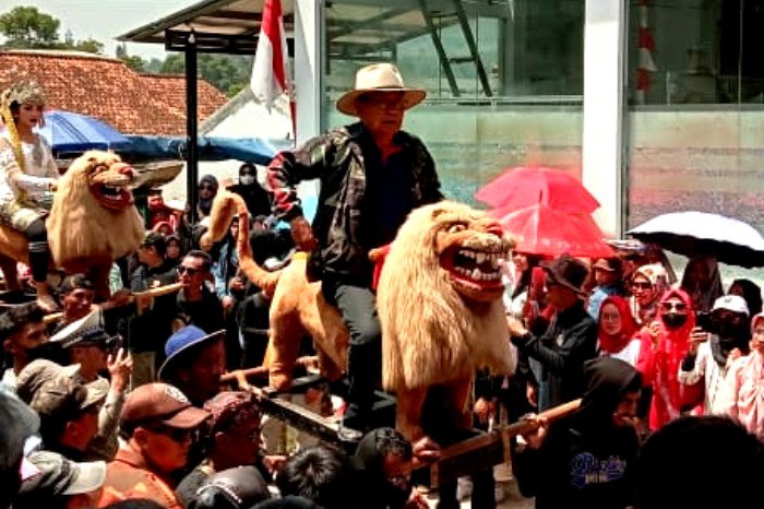 Salah seorang tokoh masyarakat terkemuka, Haji Danu Heruwinata, turut hadir memeriahkan acara Karnaval.
Beliau disambut panitia dan naik singa depok berbaur dengan iring iringan warga sambil menyawer penonton (Dok.Hallobandung.com / Dody NSH)